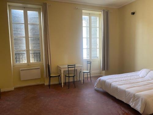 une chambre avec un lit, une table et des chaises dans l'établissement Grand Studio Roquemaure, à Roquemaure