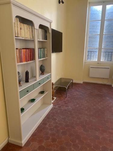 un salon avec une étagère et une fenêtre dans l'établissement Grand Studio Roquemaure, à Roquemaure