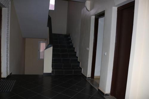 eine Treppe in einem Haus mit schwarzen Fliesenböden in der Unterkunft Appartement juste pour les familles in Ifrane
