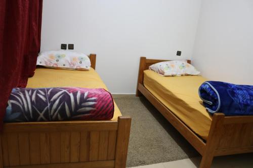 2 Einzelbetten in einem Zimmer mit gedankenlosem, gedankenlosem, gedankenlosem, gedankenlosem in der Unterkunft Appartement juste pour les familles in Ifrane
