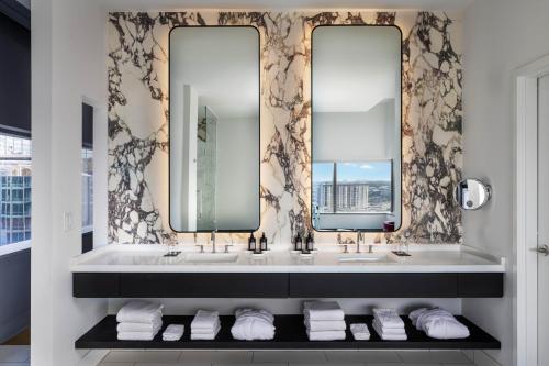 a bathroom with two sinks and two mirrors at W Austin in Austin