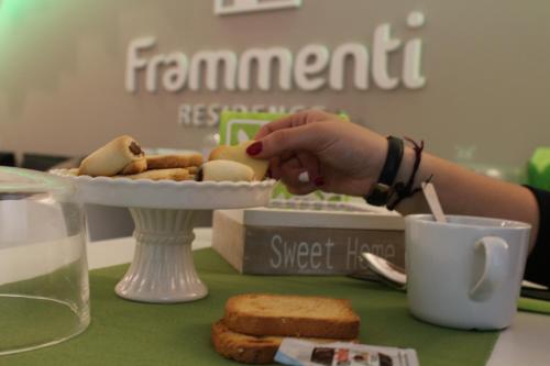 una persona che prende un piatto di cibo su un tavolo di Frammenti a Matera