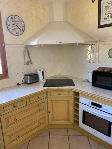 une cuisine avec un évier et une cuisinière four supérieur dans l'établissement Villa provençale pour 4 adultes et 2 enfants, à La Londe-les-Maures