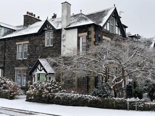 a large brick house with snow on the ground at Kirkwood Guest House in Windermere