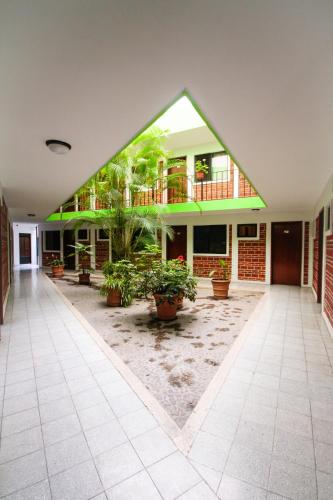 a building with potted plants in a courtyard at Hotel Arboledas Industrial in Guadalajara