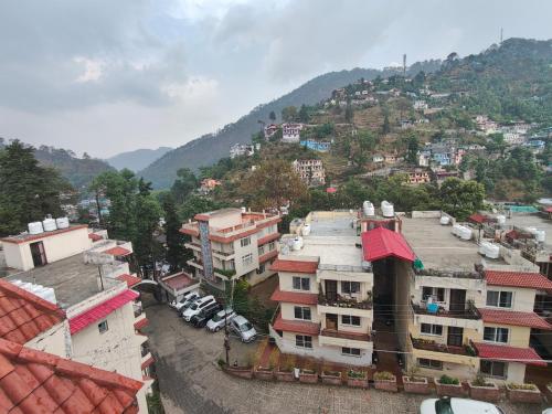 an aerial view of a city with buildings and a mountain at Hillside Haven near Kainchi Dham in Bhowāli