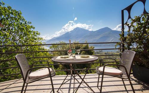 a table and chairs on a balcony with a view of a mountain at Bed and Breakfast Studios Alto lago di Como in Gravedona
