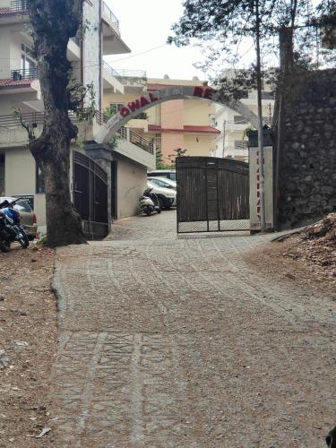 a driveway with a gate in front of a building at Hillside Haven near Kainchi Dham in Bhowāli