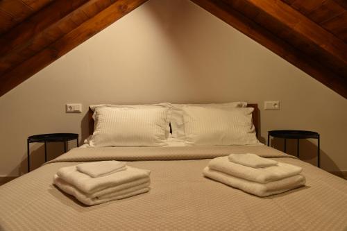 a bedroom with a bed with two towels on it at Stone Hut Apartments in Ayios Nikolaos Sithonia