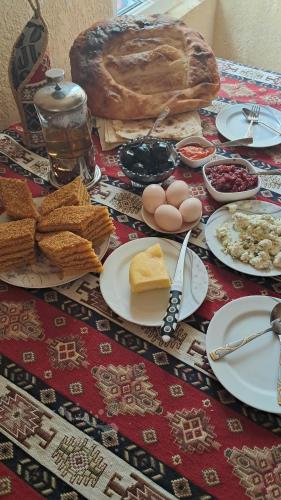a table topped with plates of food and bread at Manan Guesthouse in Chʼkalovka
