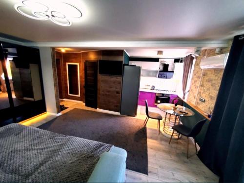 a room with a bed and a kitchen with a table at Stone city center ІІ in Kamianets-Podilskyi