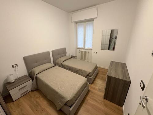 a bedroom with two beds and a table at Focolare Manzoni in Lecco
