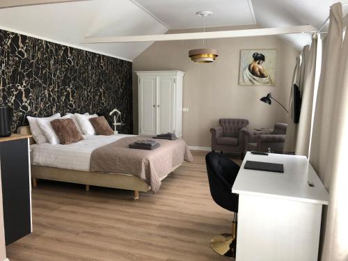 a bedroom with a bed and a desk and a chair at benbmeestervankampen in Oosterwolde