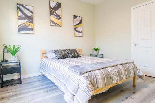 a bedroom with a bed and four paintings on the wall at 2BR Retreat Near Balboa Park in San Diego