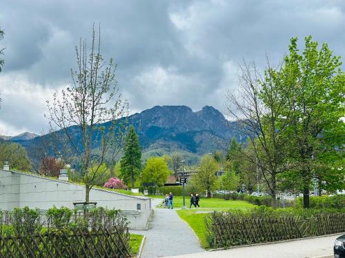 a group of people walking in a park with mountains in the background at Leśny Dworek Zakopane in Zakopane