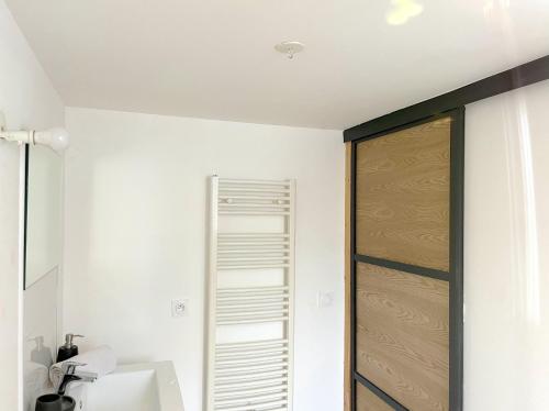La salle de bains est pourvue d'une porte en bois et d'un lavabo. dans l'établissement Duplex Tanay, à Annecy