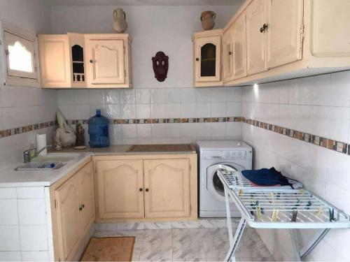 a kitchen with a washer and dryer in it at Villa Jasmin Zarzis in Zarzis