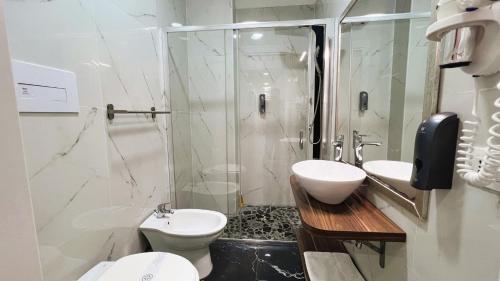 a bathroom with two sinks and a shower and a toilet at Le Sciantose Relais in Naples