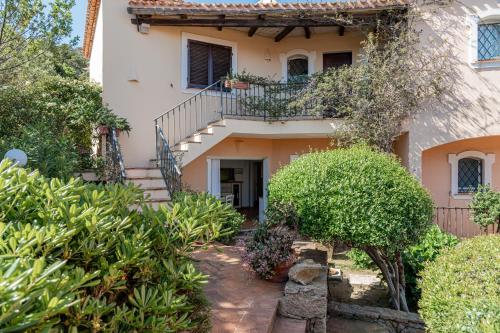 a villa with a staircase leading up to a house at Ampio Appartamento 3 Min da Porto Cervo Centro in Liscia di Vacca