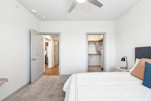 a bedroom with white walls and a bed with blue pillows at Chisholm Trace 1234 I Spacious 1 Bed 1 Bath in Cleburne