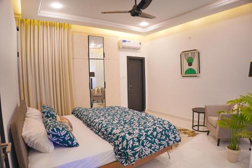 a bedroom with a bed with blue and white sheets at Mirpur Modern Spanish Villa - Elegant Comfort in the Heart of the City in New Mīrpur