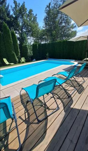 a group of chairs sitting next to a swimming pool at gîte de charme avec piscine et sauna in Le Thillot