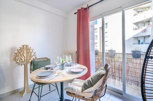 une salle à manger avec une table et des chaises et une fenêtre dans l'établissement Appartement Rochat - Welkeys, à Antibes