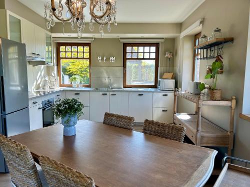 a kitchen with a table and chairs and a dining room at Au Coeur des Collines, Doucette in Ellezelles