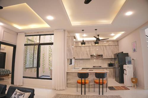 a kitchen with a counter and stools in a room at Mirpur Modern Spanish Villa - Elegant Comfort in the Heart of the City in New Mīrpur