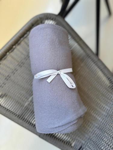 a roll of toilet paper with a bow on a basket at Brillante Apartament in Floreşti