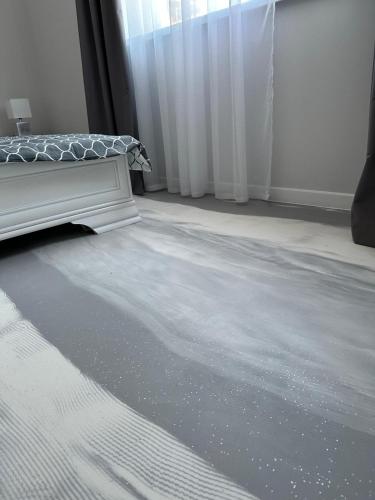 a bedroom with a white bed and a window at Brillante Apartament in Floreşti