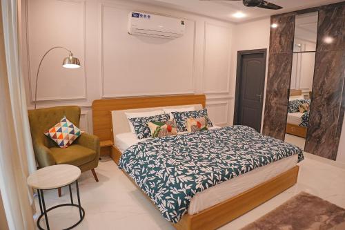 a small bedroom with a bed and a chair at Mirpur Modern Spanish Villa - Elegant Comfort in the Heart of the City in New Mīrpur