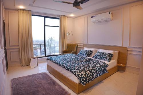 a bedroom with a bed and a large window at Mirpur Modern Spanish Villa - Elegant Comfort in the Heart of the City in New Mīrpur