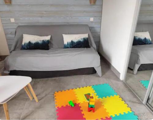 une chambre avec un lit et un tapis lego dans l'établissement Ossau T2 5 personnes tt confort climatisation piscine linge de maison inclus moustiquaires vue montagne plein sud, à Bielle