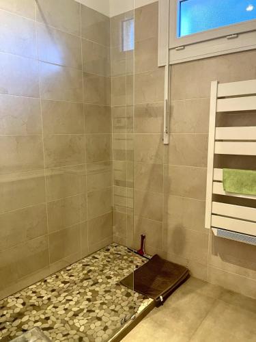 La salle de bains est pourvue d'une douche et d'un sol en pierre. dans l'établissement Le Cezanne Wifi Clim Centre ville, à Cassis