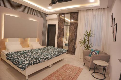 a bedroom with a bed and a couch and a chair at Mirpur Modern Spanish Villa - Elegant Comfort in the Heart of the City in New Mīrpur