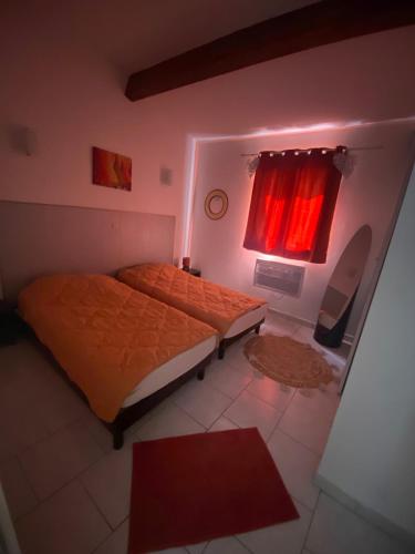 - une chambre avec 2 lits et une fenêtre avec des rideaux rouges dans l'établissement Maison T3, à Piana