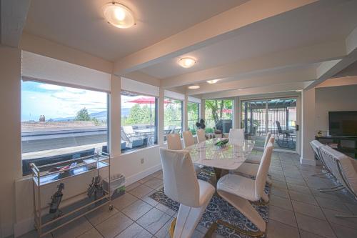 a dining room with a table and chairs and windows at Private Bedroom, Bathroom, Shared Outdoor Pool, Hot Tub in North Vancouver
