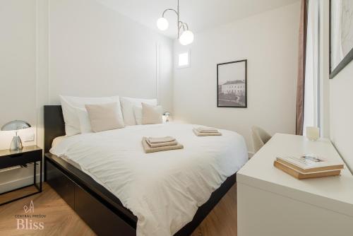 a bedroom with a white bed with towels on it at Central Presov Bliss, right in the center with 1 free parking spot in Prešov