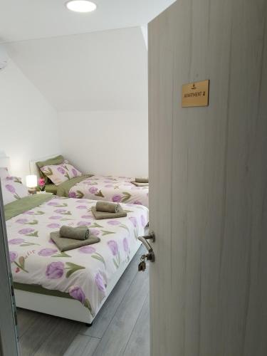 a bedroom with two beds and a open door at Apartments Honey House in Trebinje