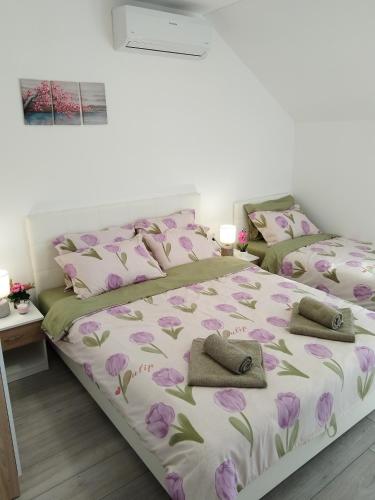 a bedroom with two beds with pink and green flowers at Apartments Honey House in Trebinje