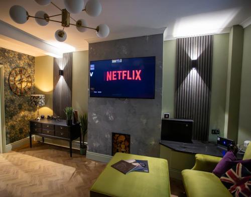 una sala de estar con una señal de netflix en la pared en NEW Refurbished 2025 Cottage Sleeps 6 Ashbourne Peak District Derbyshire, en Ashbourne