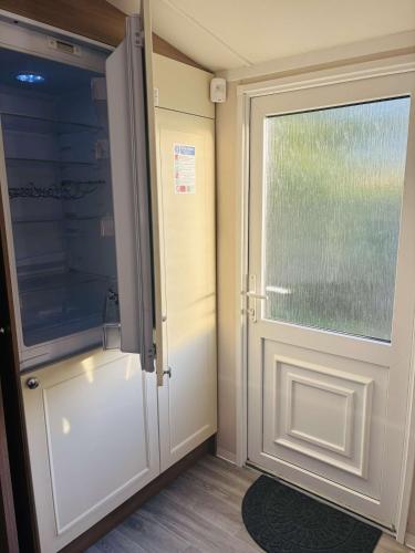 a door with a window in a room at Haven Holiday Park, Kent Coast in Allhallows
