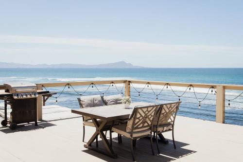 a table and chairs on a deck with the ocean at Casa Puesta Del Sol An Oceanview House in El Suazal
