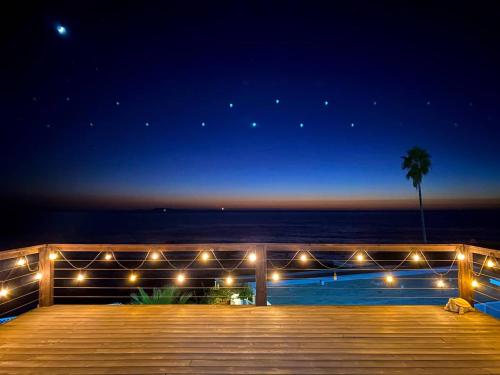 a deck with a view of the ocean at night at Casa Puesta Del Sol An Oceanview House in El Suazal