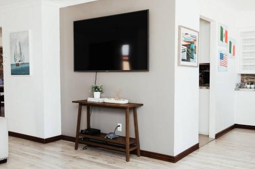 a living room with a television on a wall at Casa Puesta Del Sol An Oceanview House in El Suazal