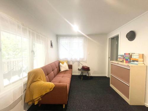 a living room with a brown couch and a window at The Napier Nook in Napier