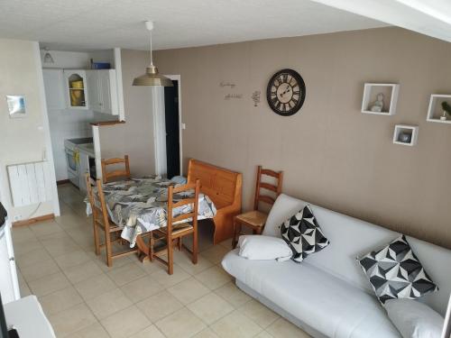 - un salon avec un canapé, une table et un réveil dans l'établissement Saint Hilaire de Riez appartement T2 a 200m mer, à La Celle-sous-Gouzon