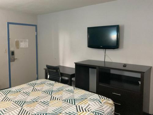 a bedroom with a bed and a tv on the wall at Motel 6 Baton Rouge East, LA I12 in Baton Rouge