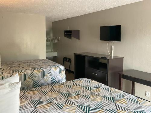a hotel room with two beds and a flat screen tv at Motel 6 Baton Rouge East, LA I12 in Baton Rouge